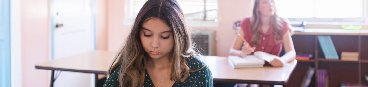 Duas adolescentes em uma sala de aula de uma escola