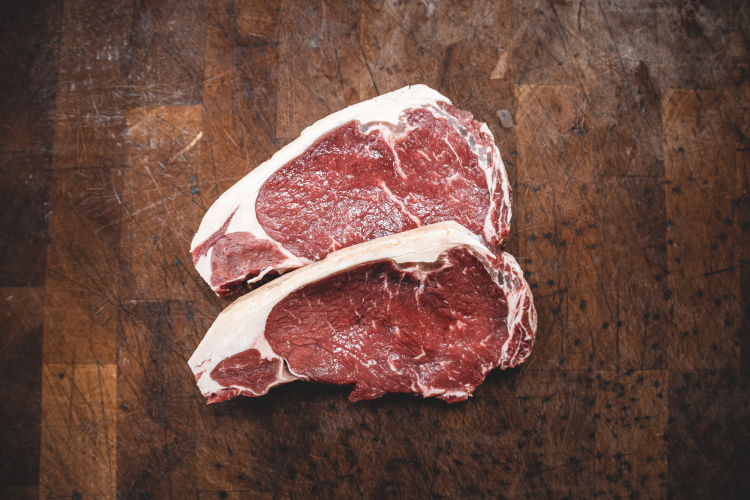 Dois bifes de carne vermelha crua em cima de uma tábua