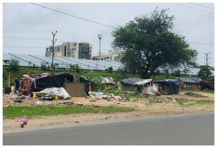 Imagem de barracos pobres em um meio urbano e, ao fundo, a imagem de edifícios. A imagem mostra um pouco da desigualdade social no mundo