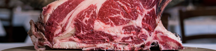 Uma enorme peça de carne vermelha crua em cima de uma bancada