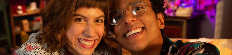 Uma mulher e um homem estão lado a lado e sorrindo.