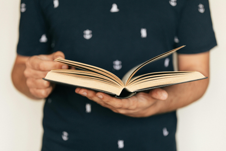 Um rapaz com um livro em suas mãos
