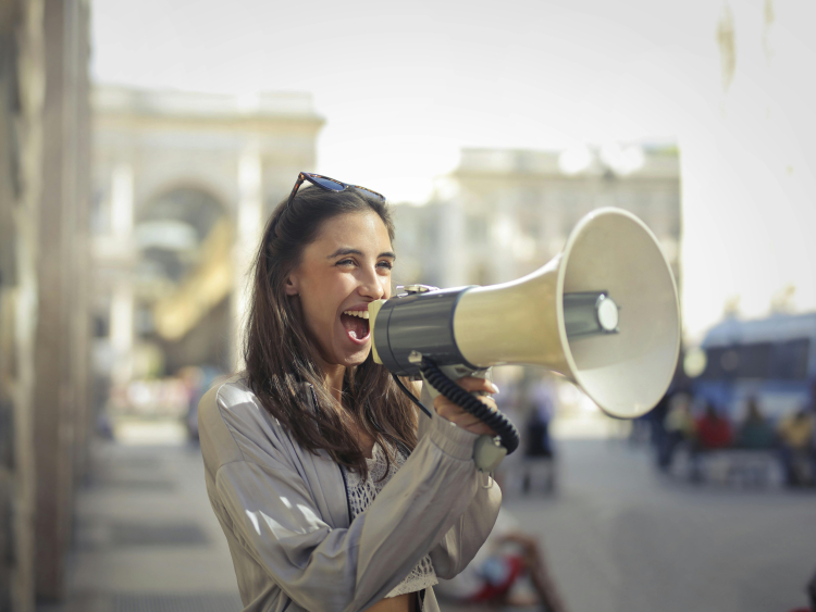 Uma menina usando um megafone na rua