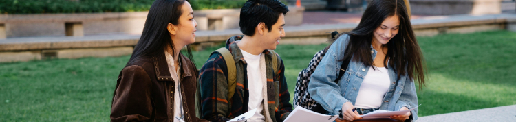 três jovens sentados e estudando