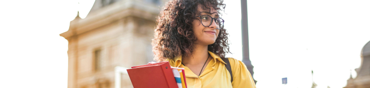 mulher preta com livros na mão