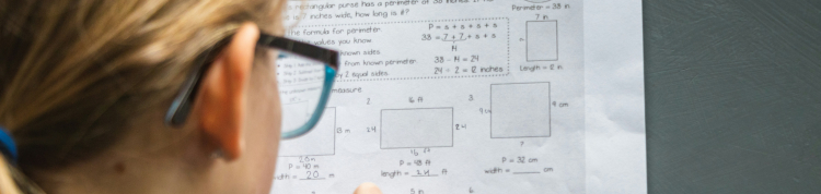 Uma menina fazendo exercícios de matemática em um papel