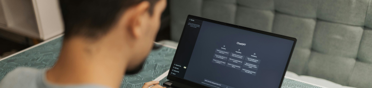 A imagem mostra um jovem rapaz usando um notebook com o chatgpt aberto