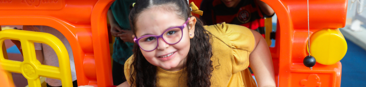 A imagem mostra uma menina brincando em um parquinho